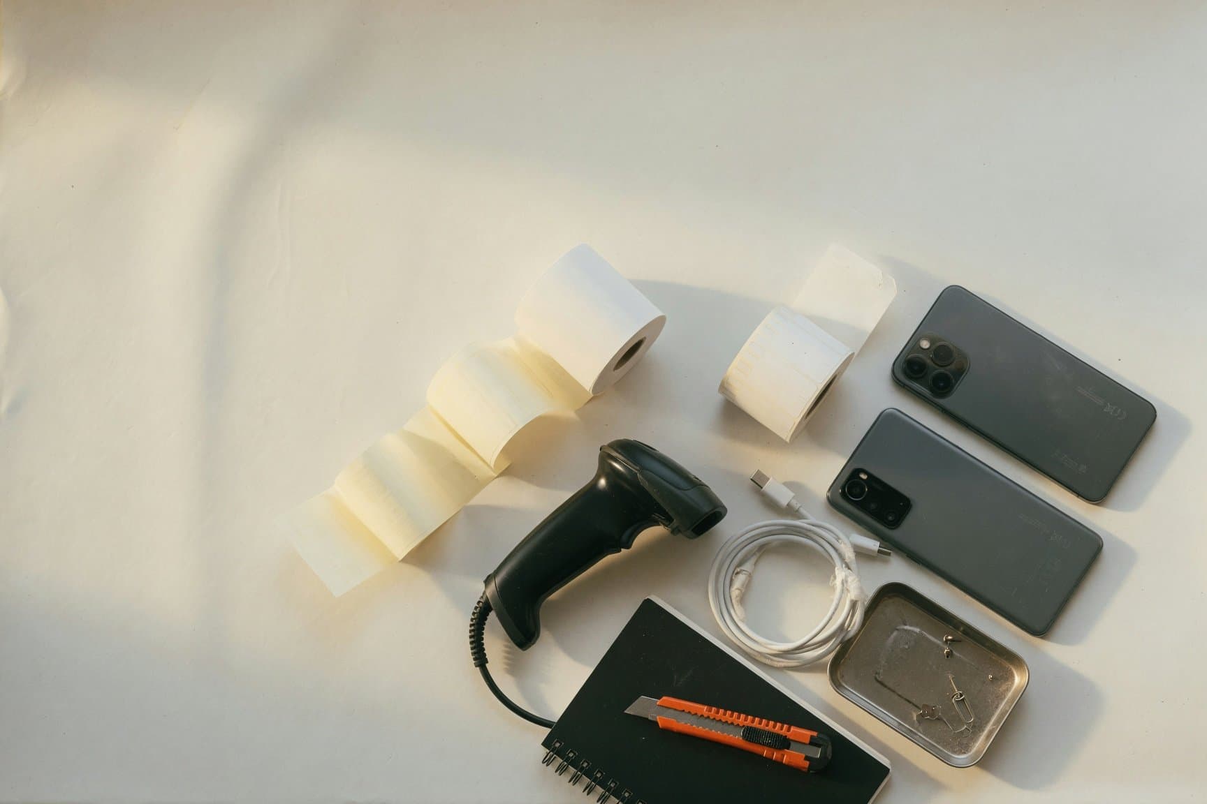 Counter of a mobile phone shop: receipt roll, scanner and label stock